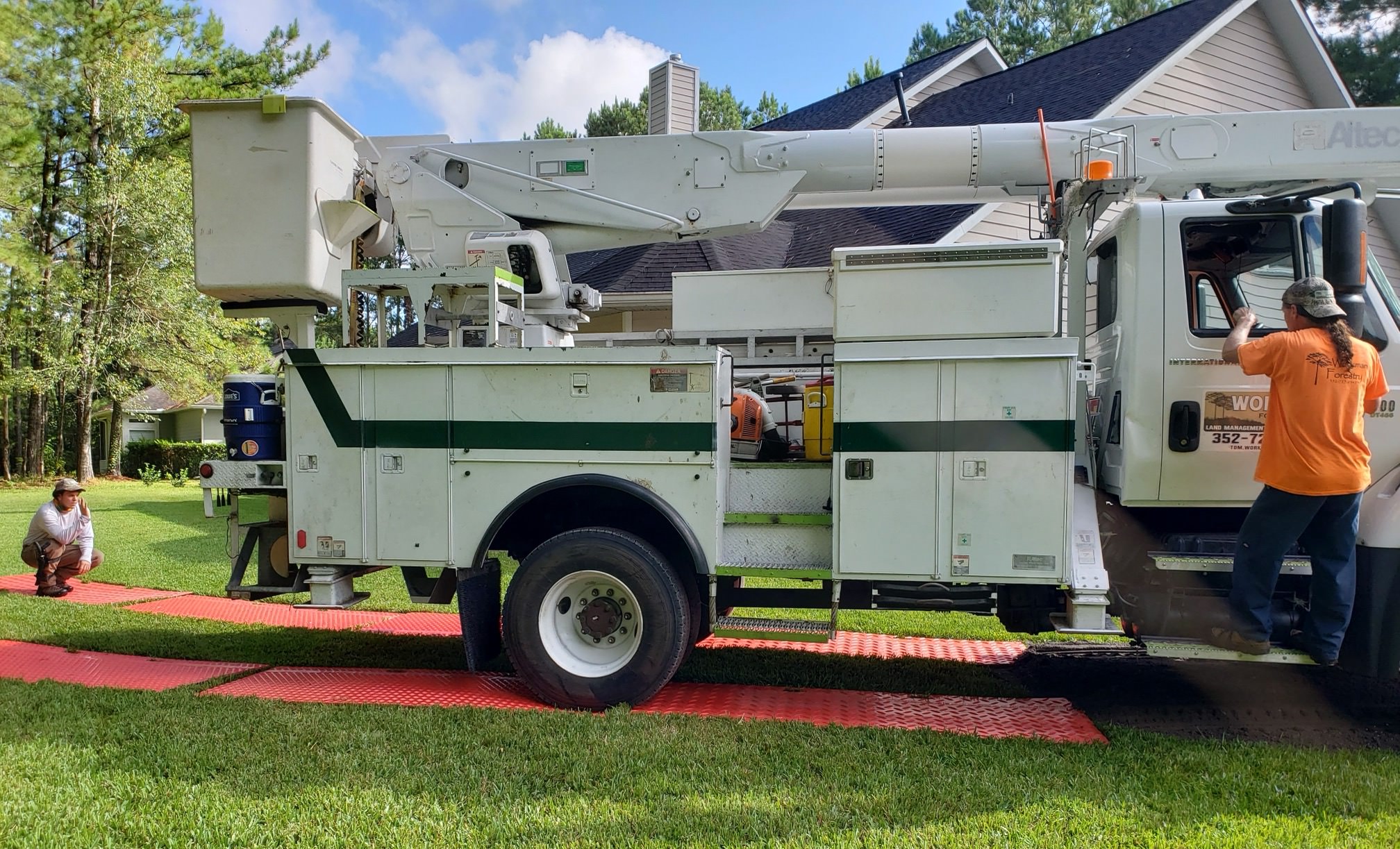 Bucket truck with ground protection mats during tree removal